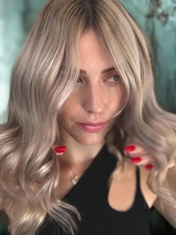 Portrait d’une femme avec un balayage blond froid et des ondulations élégantes, réalisée par le salon WB Coiffure.